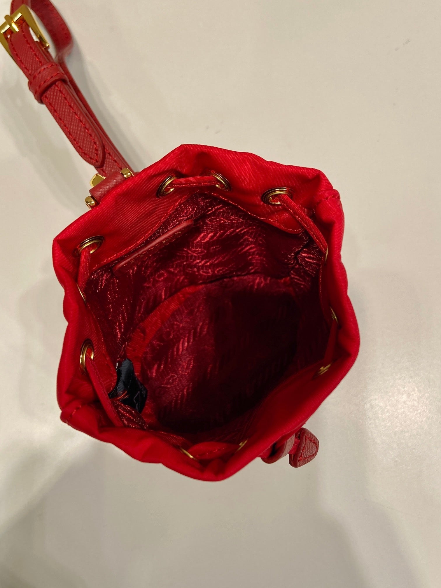 MINI BUCKET BAG 10 IN RED RE-NYLON AND SAFFIANO LEATHER STRAP