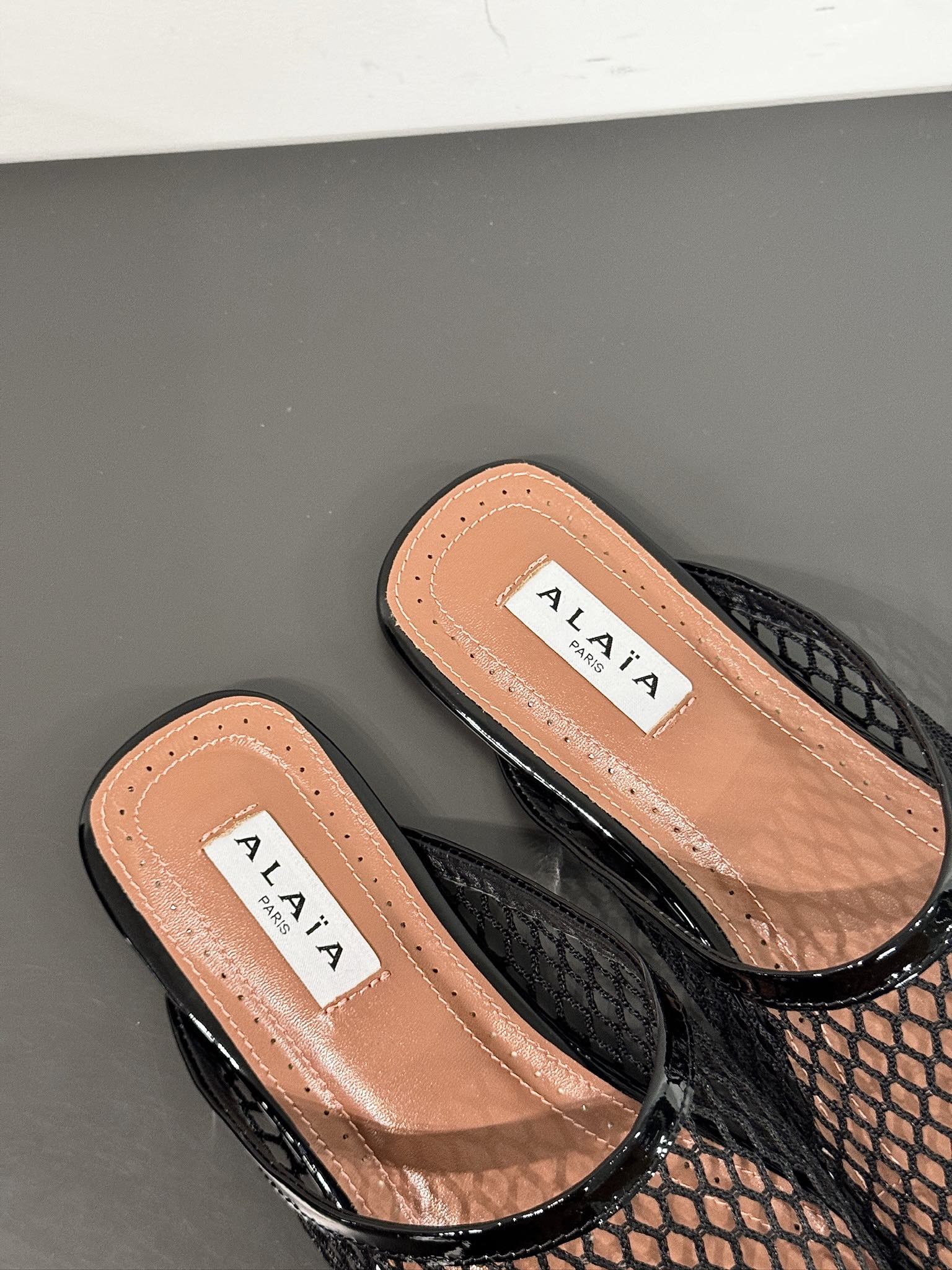 ALAIA FLAT MULES IN BLACK MESH FISHNET
