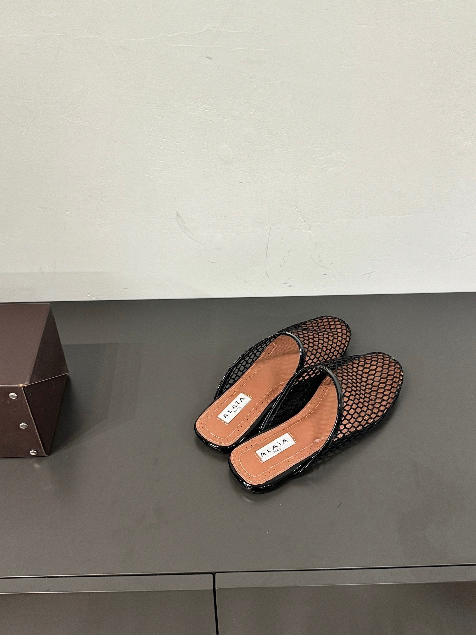 ALAIA FLAT MULES IN BLACK MESH FISHNET