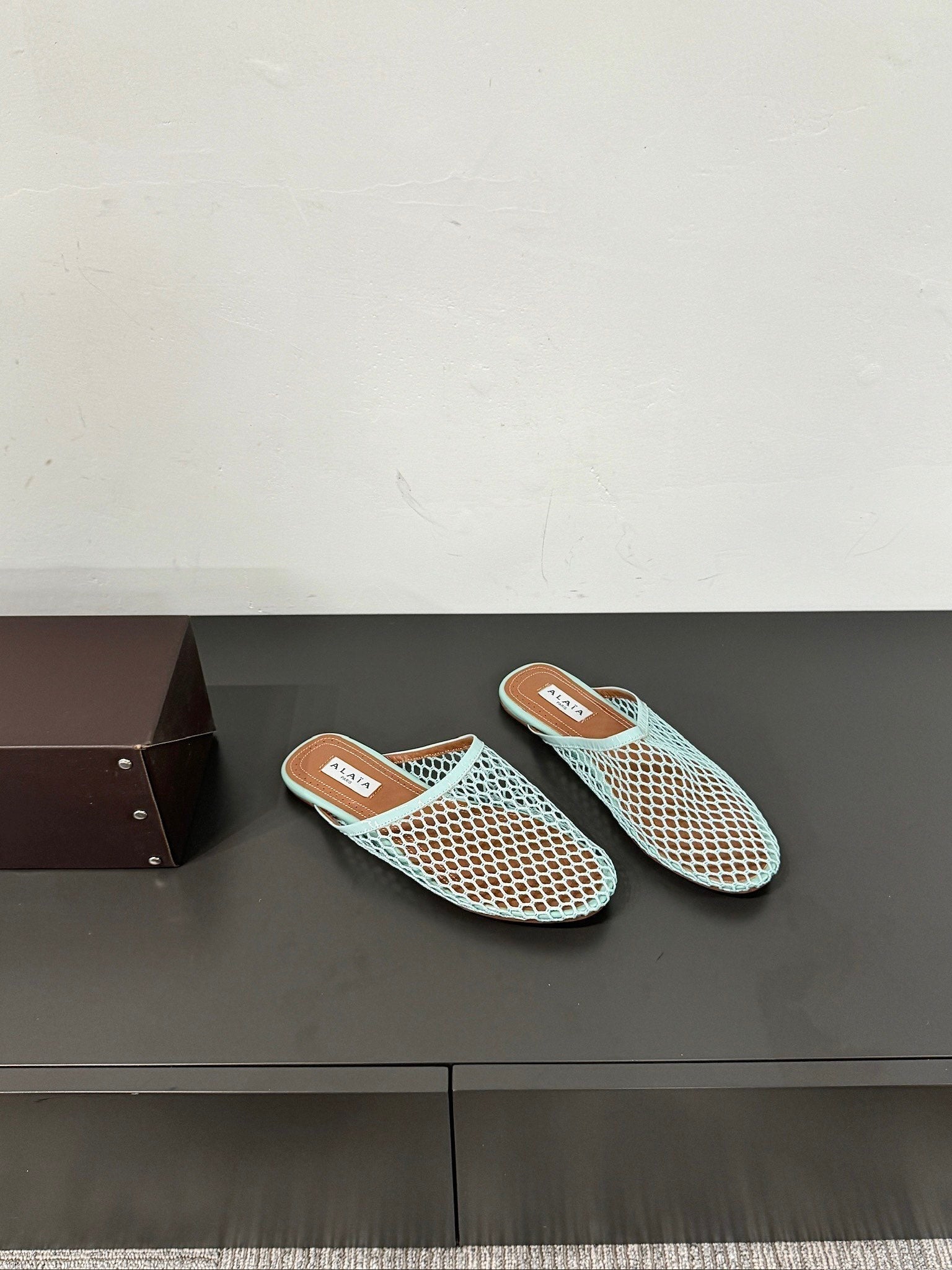 ALAIA FLAT MULES IN LIGHT BLUE MESH FISHNET