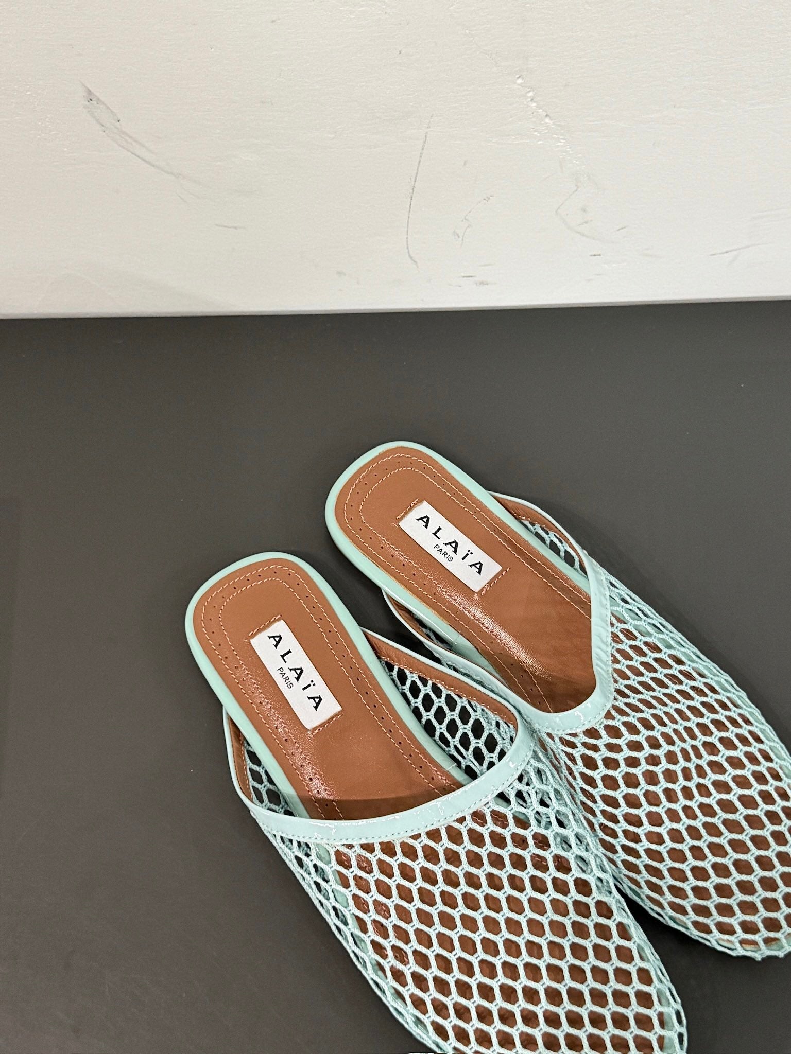 ALAIA FLAT MULES IN LIGHT BLUE MESH FISHNET