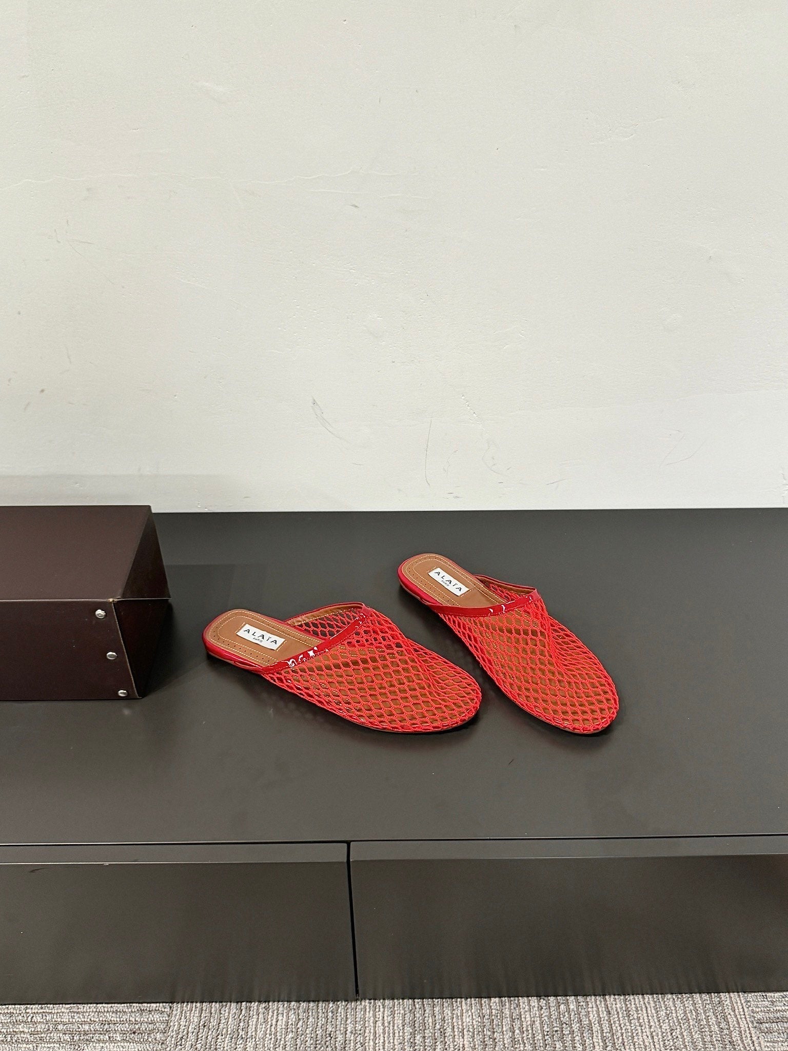 ALAIA FLAT MULES IN CHERRY RED MESH FISHNET