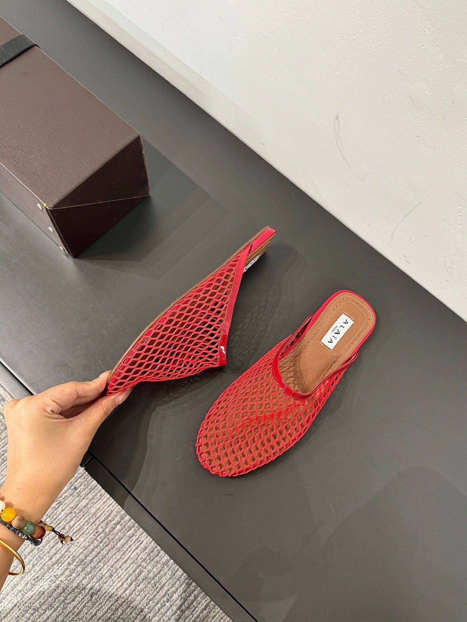 ALAIA FLAT MULES IN CHERRY RED MESH FISHNET