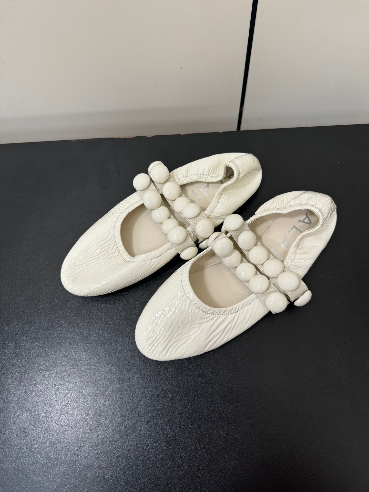 ALAIA SPHERE BALLET FLATS IN WHITE LAMBSKIN