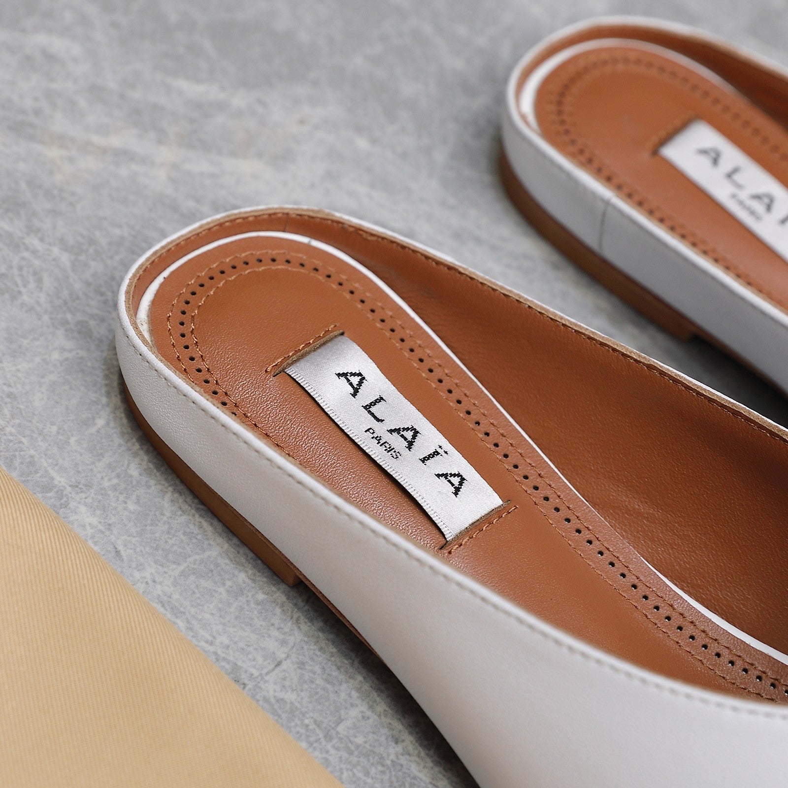 ALAIA FLAT MULE IN WHITE LAMBSKIN