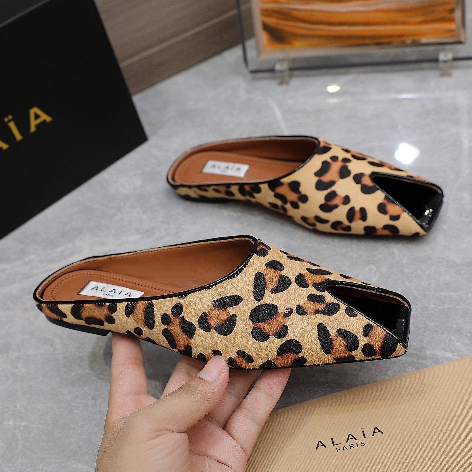 ALAIA FLAT MULE IN LEOPARD LAMBSKIN