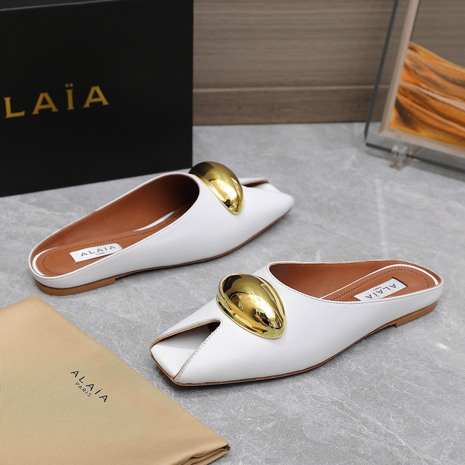 ALAIA FLAT MULE IN WHITE LAMBSKIN WITH GOLD HARDWARE